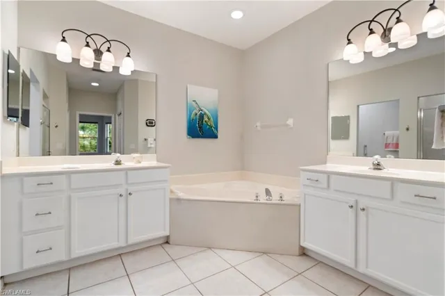 a bathroom with a double vanity sink mirror and bathtub