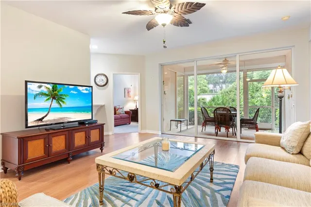 a living room with furniture a flat screen tv and a large window