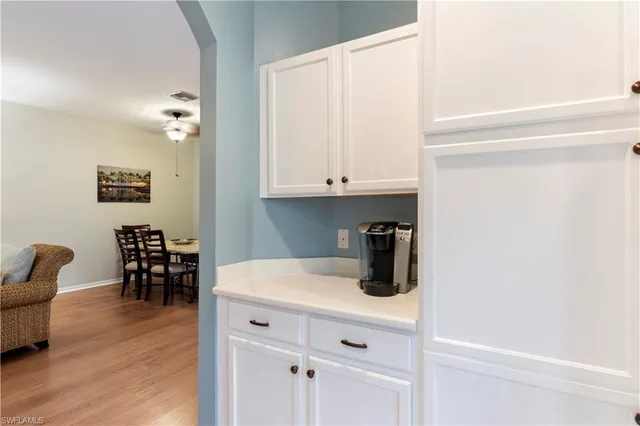 a kitchen with a white cabinets and wooden floor