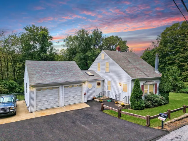 a front view of a house with a garden and yard