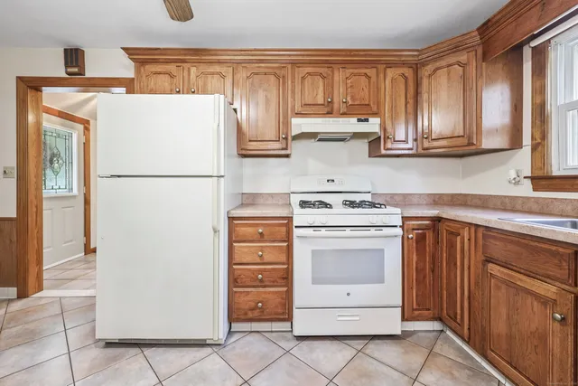 a kitchen with a white stove refrigerator and cabinets