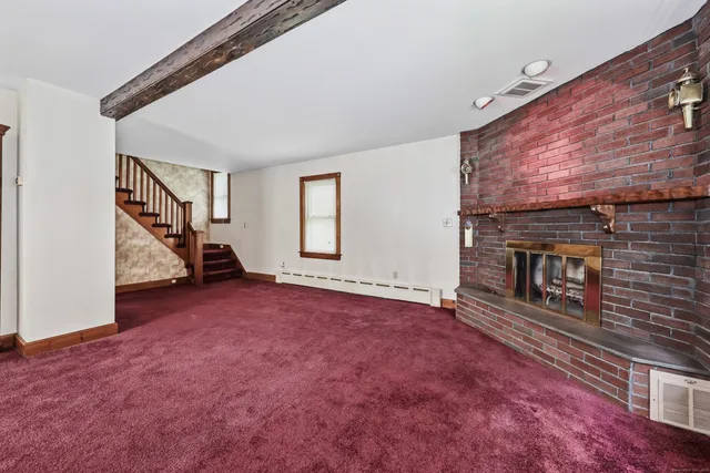 an empty room with fireplace and windows