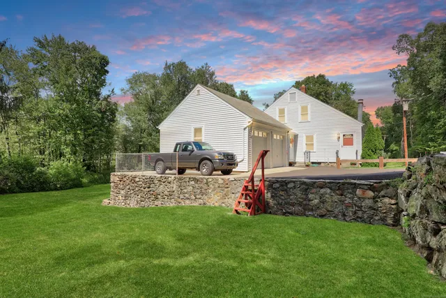 a view of a house with a backyard and a garden