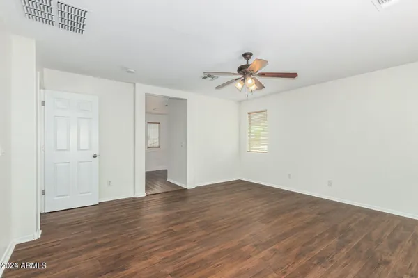 a view of a big room with wooden floor and a ceiling fan