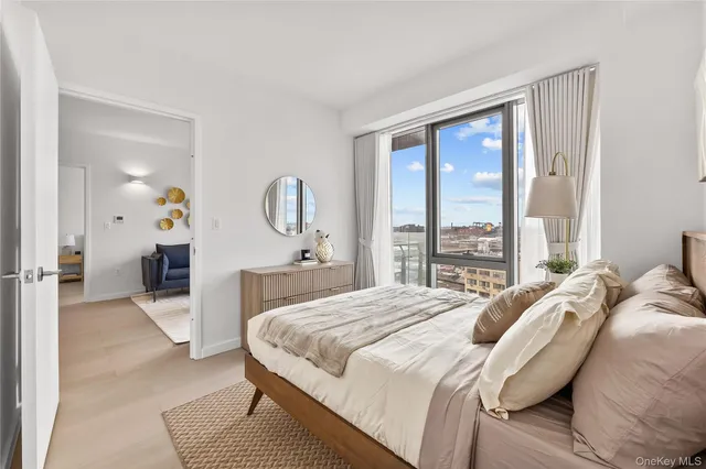 a bedroom with a bed a mirror and a large window