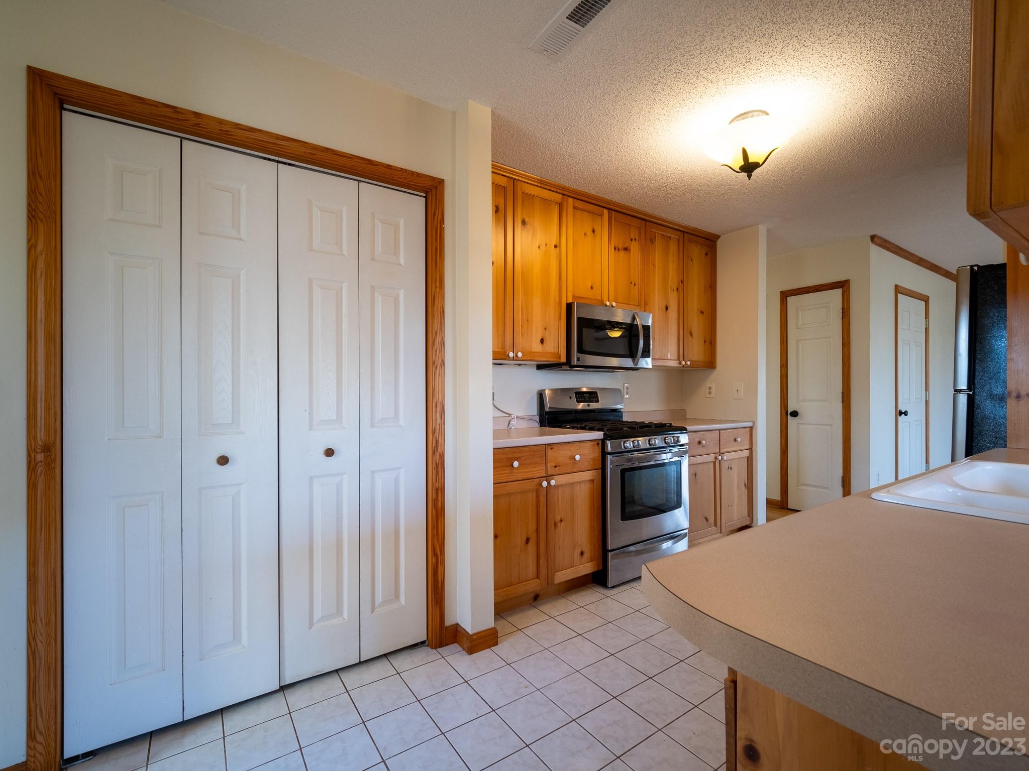 430 Jeep Road Brevard, NC 28712 - Photo 23 of 45 a kitchen with stainless steel appliances granite countertop a refrigerator a stove and a sink with wooden floor