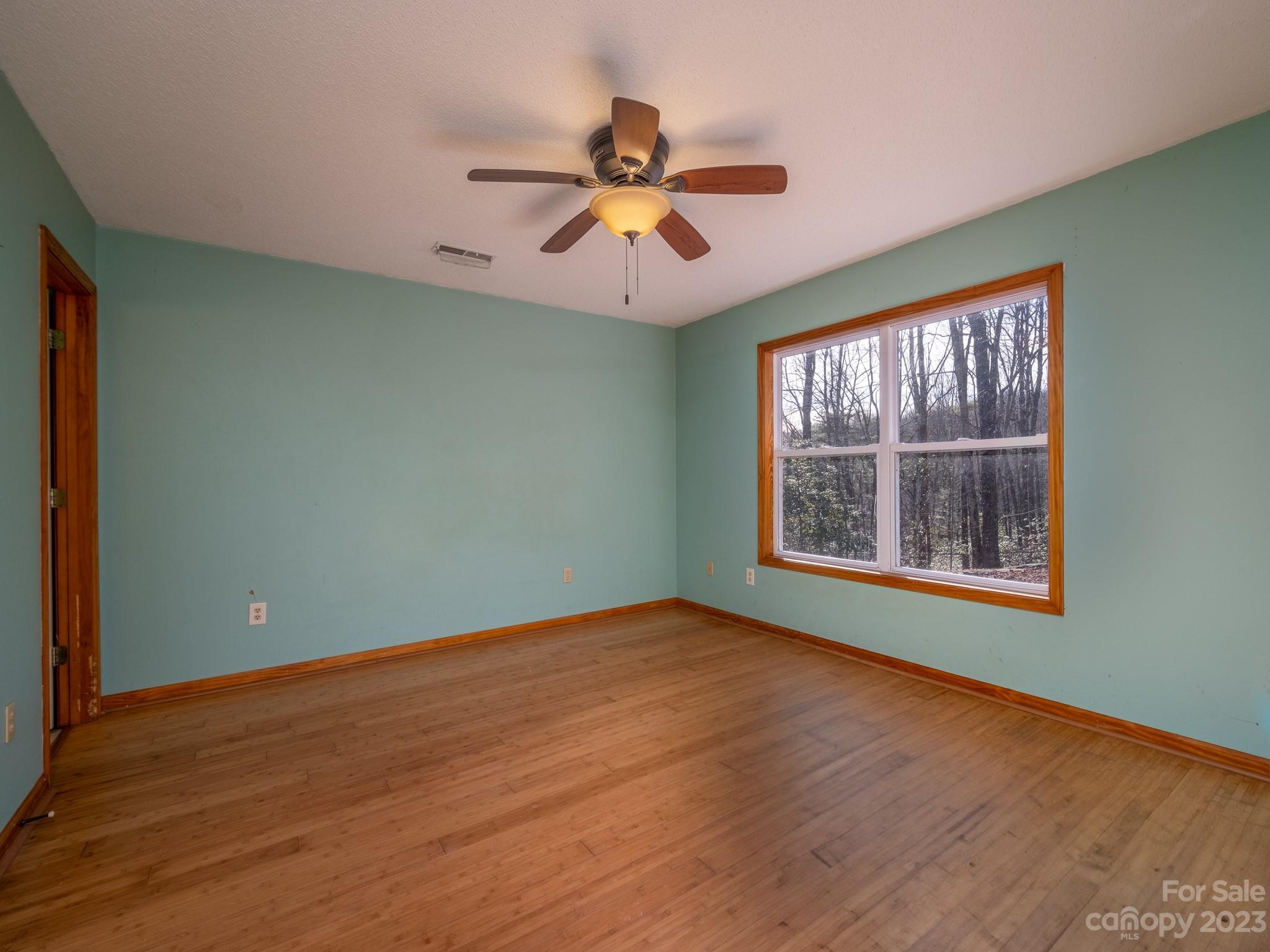 430 Jeep Road Brevard, NC 28712 - Photo 31 of 45 an empty room with wooden floor chandelier and windows