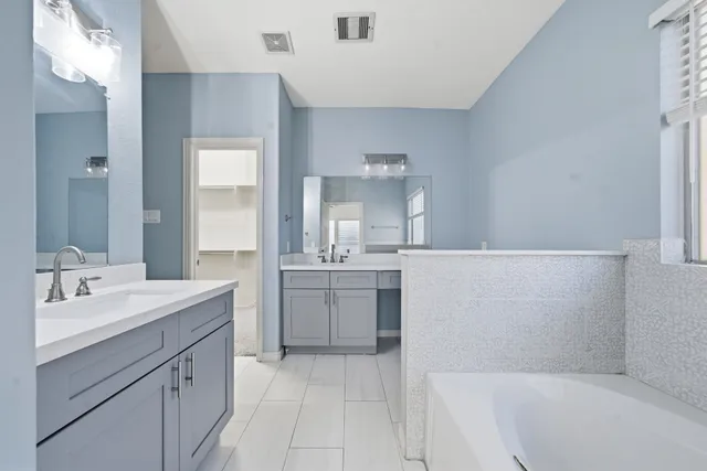 a bathroom with a tub sink and mirror