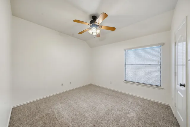 an empty room with a window and a ceiling fan