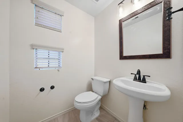 a bathroom with a toilet sink and mirror