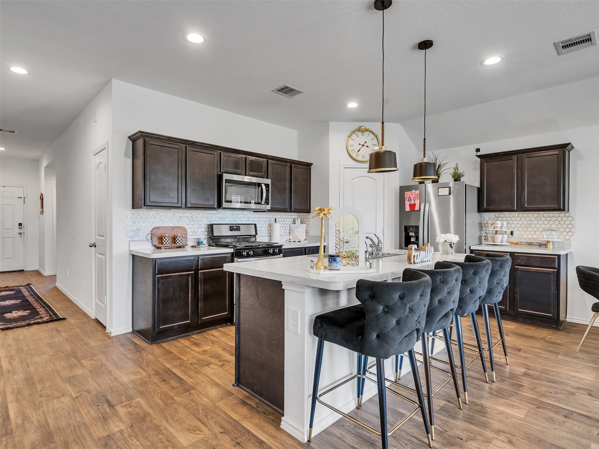 21215 Audubon Russet Road Katy, TX 77449 - Photo 11 of 30 a kitchen with stainless steel appliances granite countertop a stove top oven a sink dishwasher a dining table and chairs with wooden floor