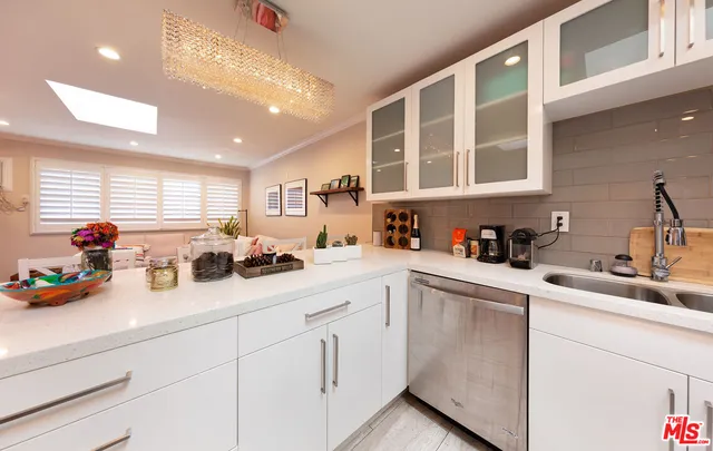 a open kitchen with stainless steel appliances granite countertop a refrigerator and a sink