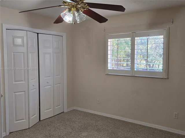 a view of a livingroom with a ceiling fan and window