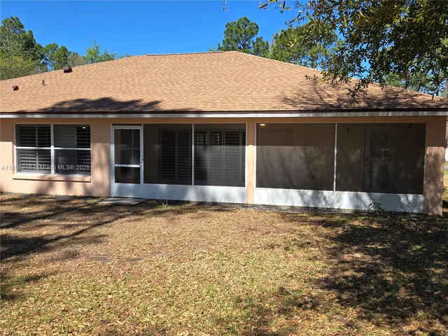 a view of a white house with a sink and yard