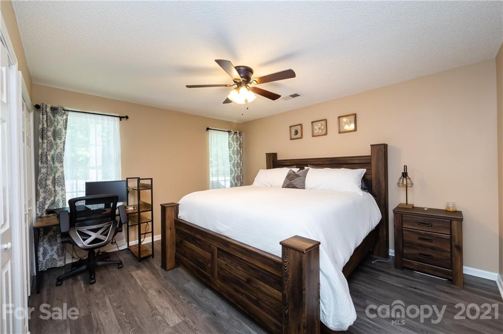 11207 Gold Pan Road Charlotte, NC 28215 - Photo 11 of 19 a bedroom with a bed and a chandelier