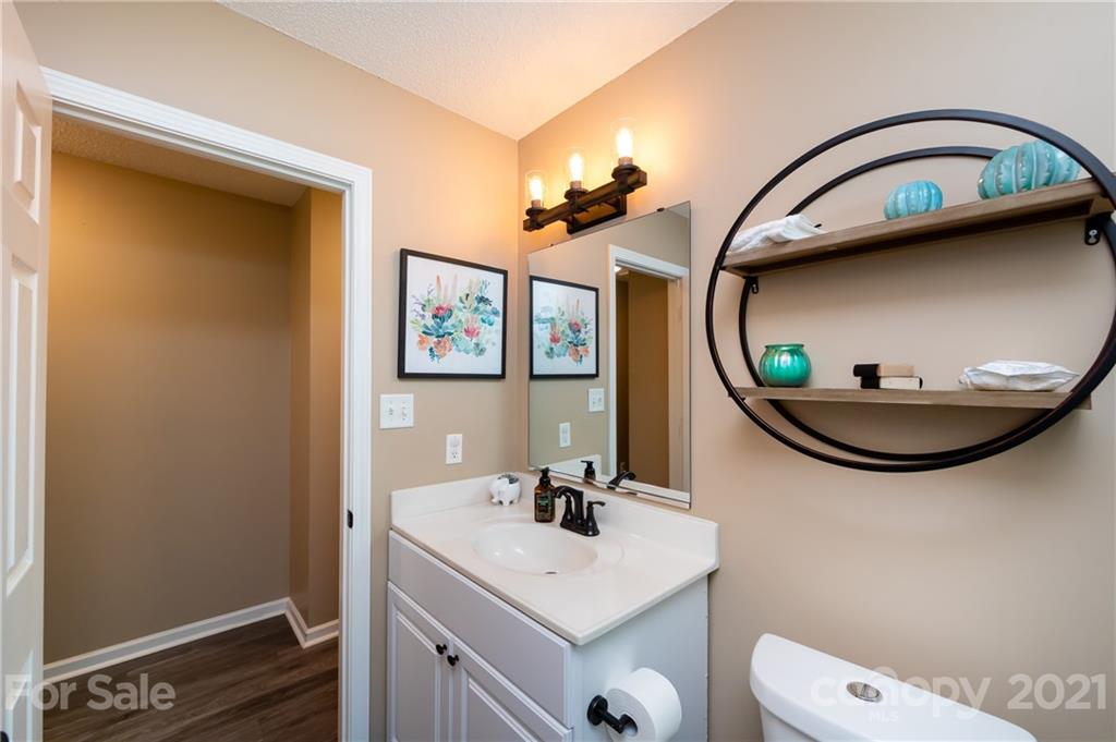 11207 Gold Pan Road Charlotte, NC 28215 - Photo 14 of 19 a bathroom with a sink a mirror and a toilet