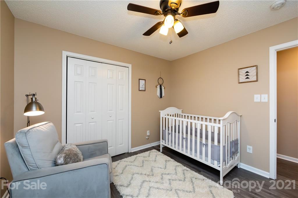 11207 Gold Pan Road Charlotte, NC 28215 - Photo 16 of 19 a living room with a baby crib furniture and a window