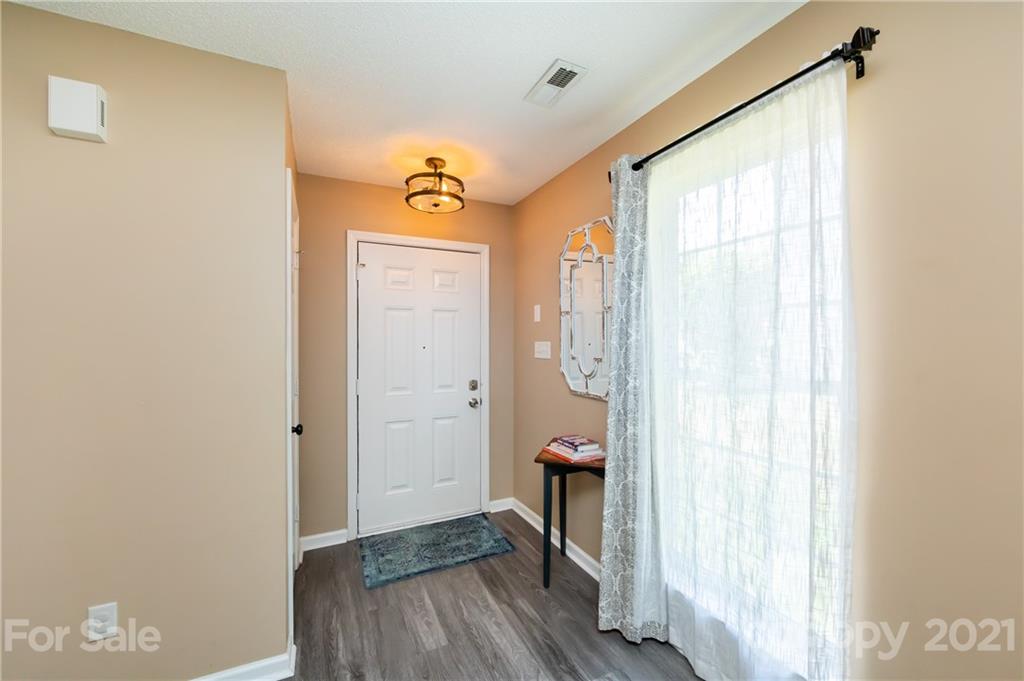 11207 Gold Pan Road Charlotte, NC 28215 - Photo 3 of 19 a view of a hallway with wooden floor and a bathroom