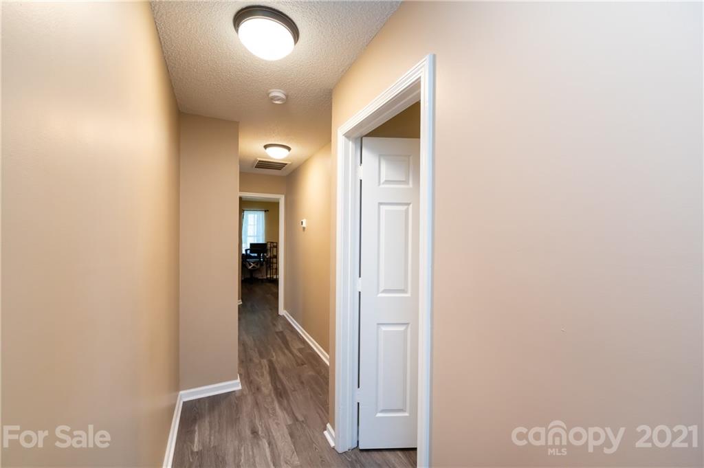 11207 Gold Pan Road Charlotte, NC 28215 - Photo 10 of 19 a view of a hallway with wooden floor and closet