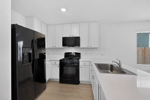 a kitchen with stainless steel appliances a refrigerator sink and microwave
