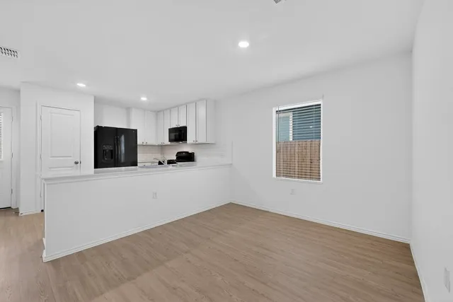 a view of a kitchen with a sink and a refrigerator