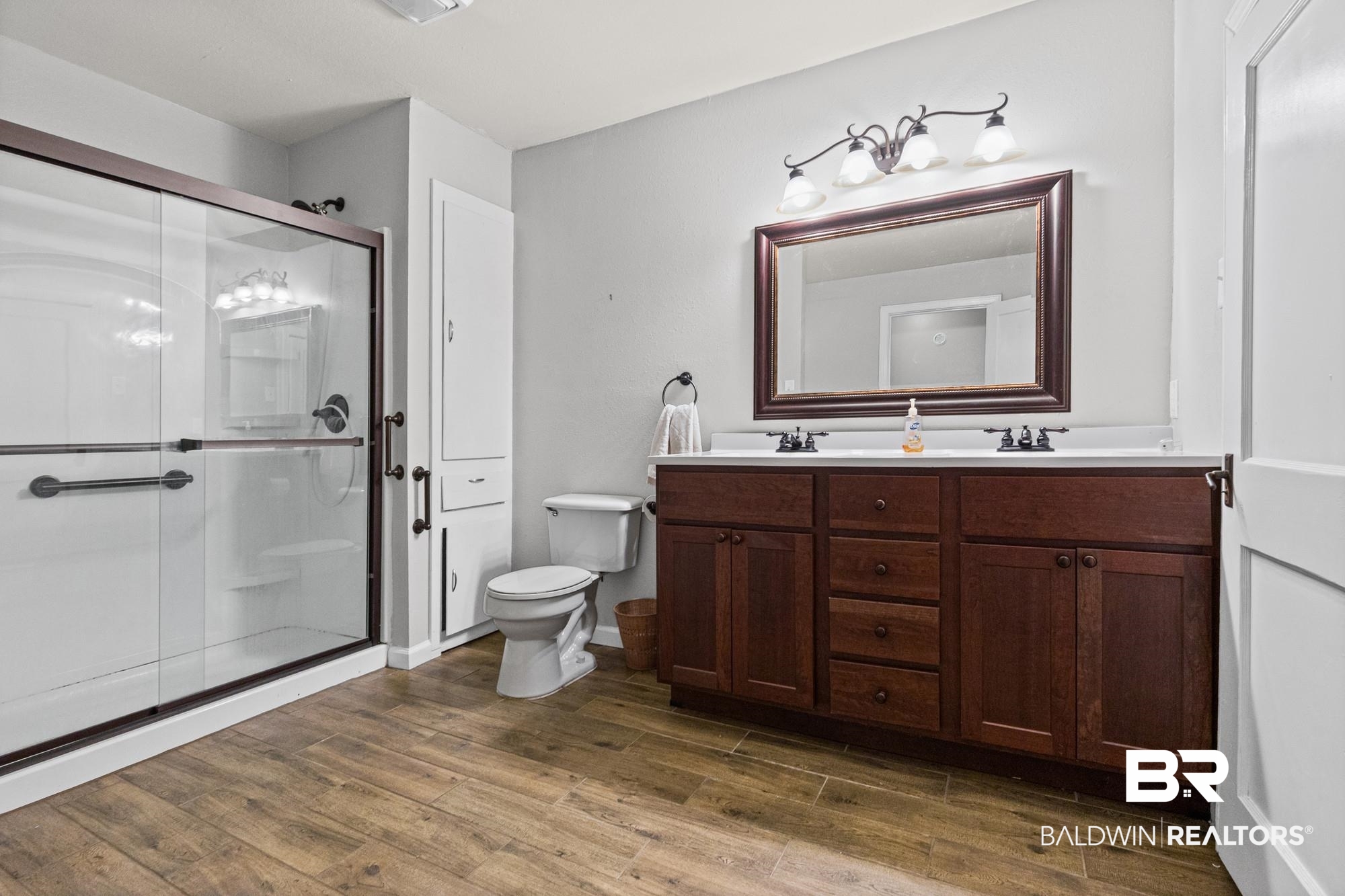 312 Sutherland Drive Mobile, AL 36611 - Photo 22 of 28 Double vanity with a white countertop and wood-finish cabinetry
