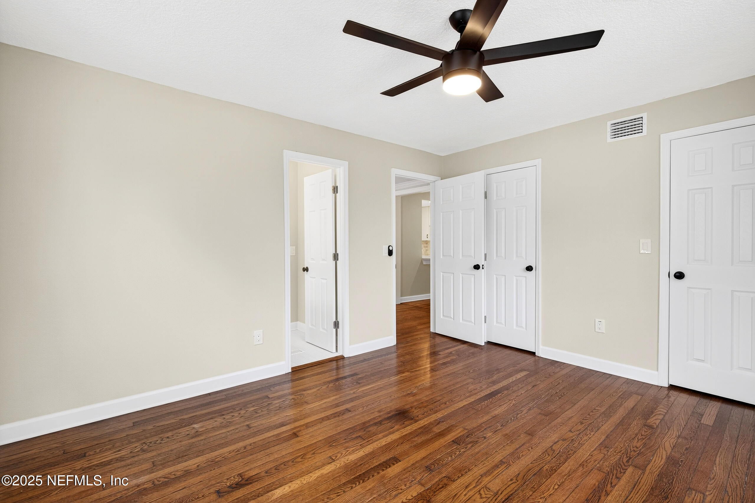 9906 Jeanette Road Jacksonville, FL 32246 - Photo 11 of 32 an empty room with wooden floor and windows