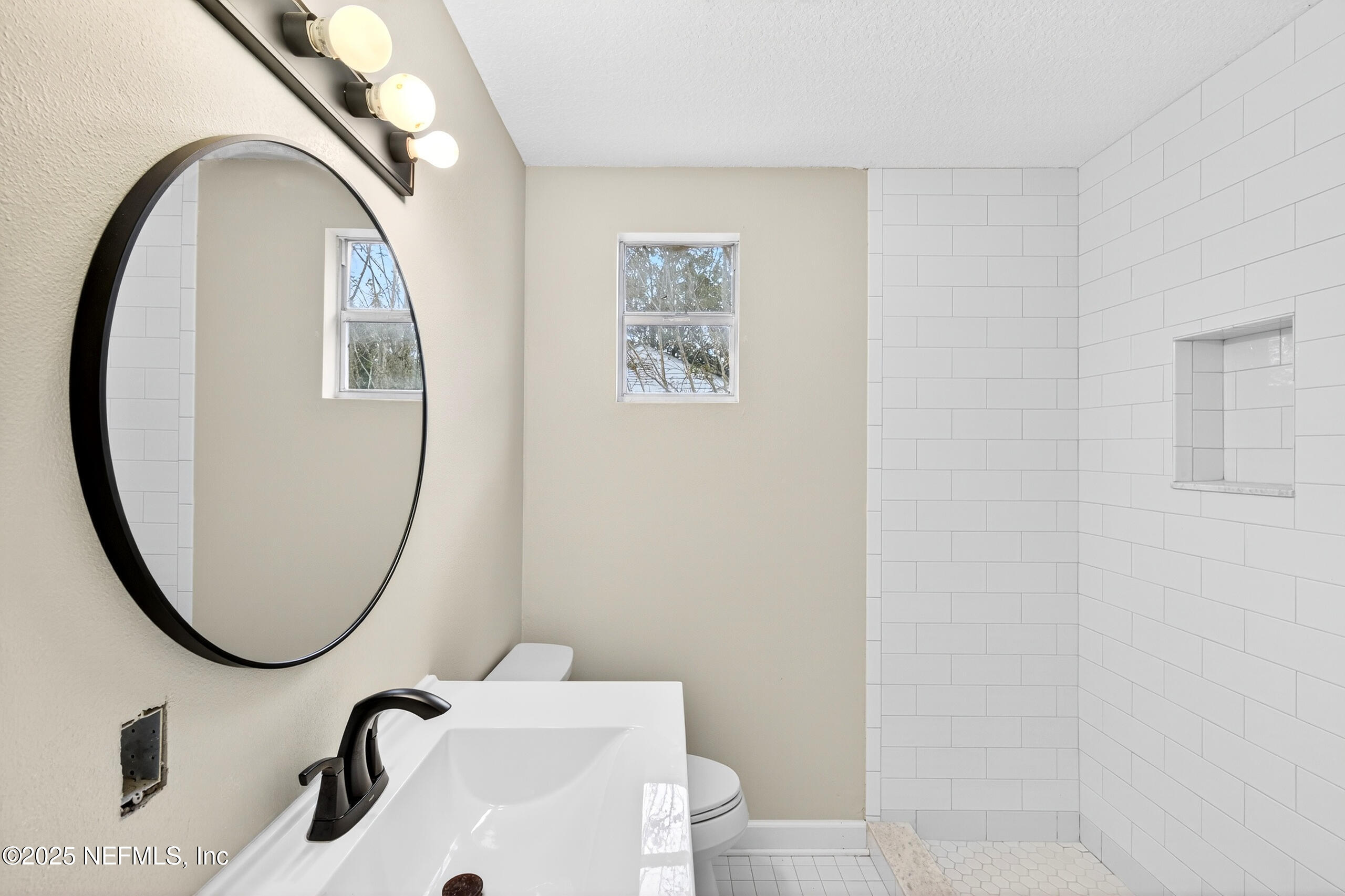 9906 Jeanette Road Jacksonville, FL 32246 - Photo 14 of 32 a bathroom with a sink and a mirror