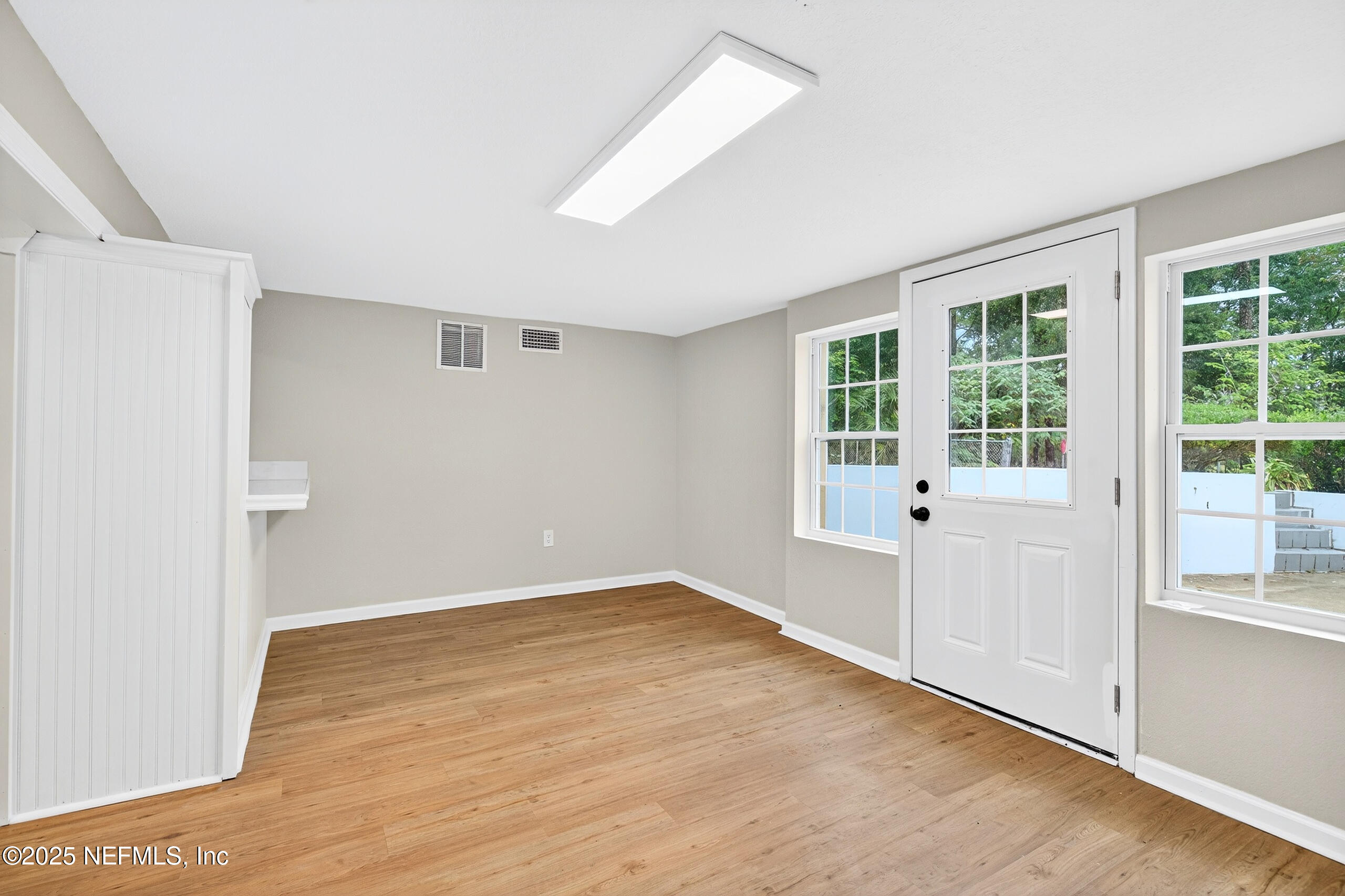 9906 Jeanette Road Jacksonville, FL 32246 - Photo 22 of 32 an empty room with wooden floor and windows