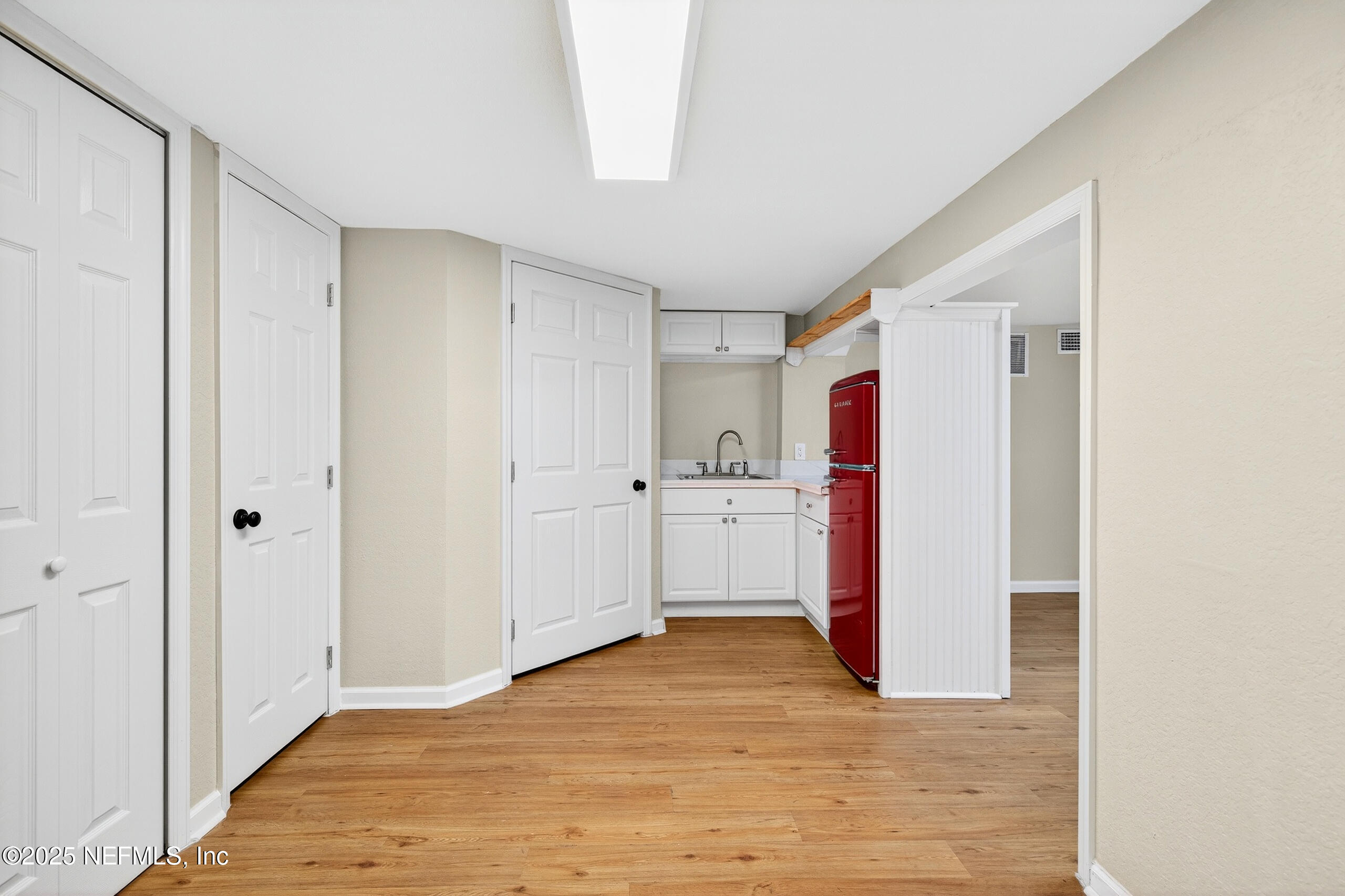 9906 Jeanette Road Jacksonville, FL 32246 - Photo 24 of 32 a view of a kitchen with white cabinets and wooden floor