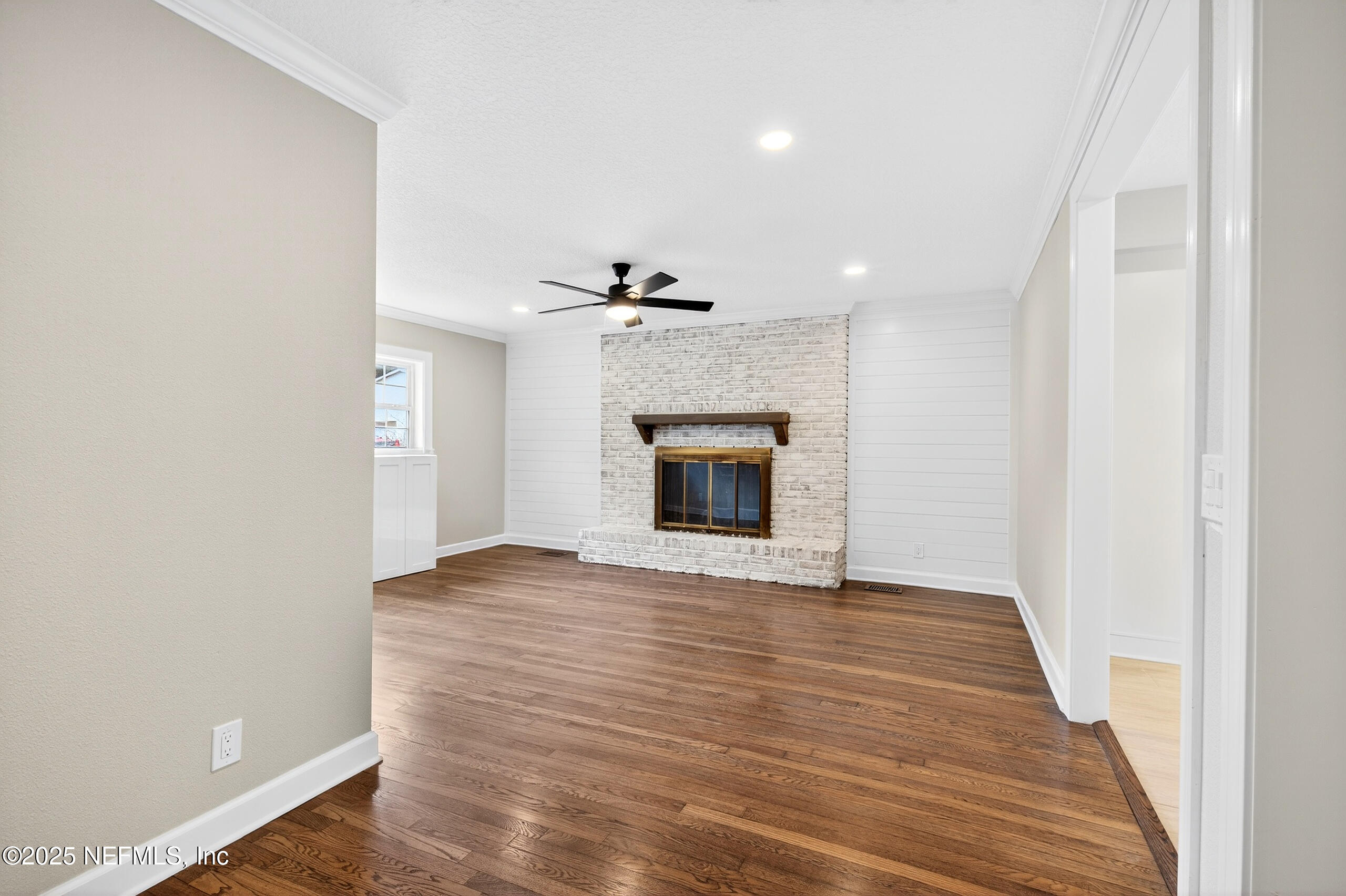 9906 Jeanette Road Jacksonville, FL 32246 - Photo 5 of 32 a view of an empty room with a fireplace and a window