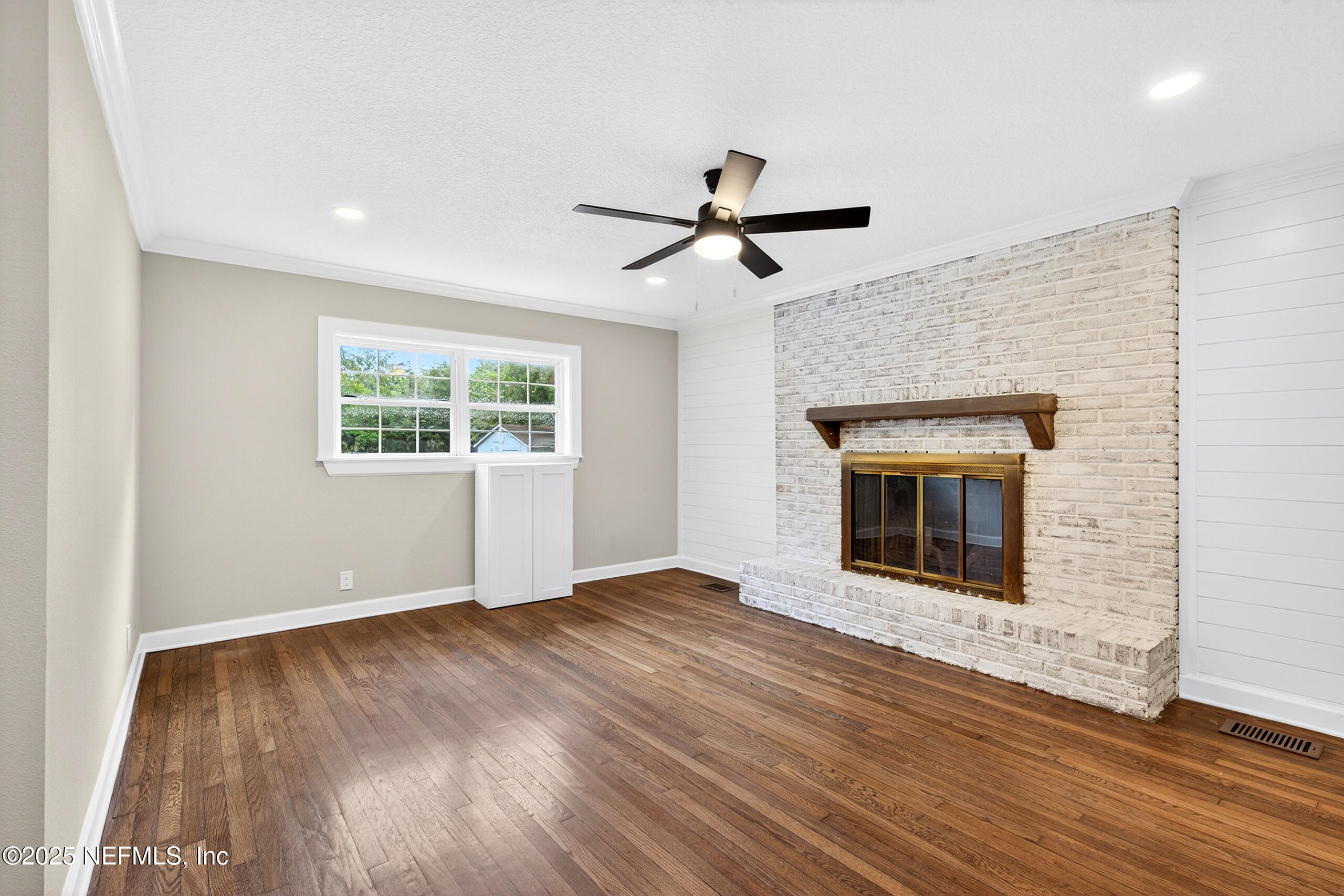 9906 Jeanette Road Jacksonville, FL 32246 - Photo 6 of 32 a view of empty room with wooden floor and fireplace