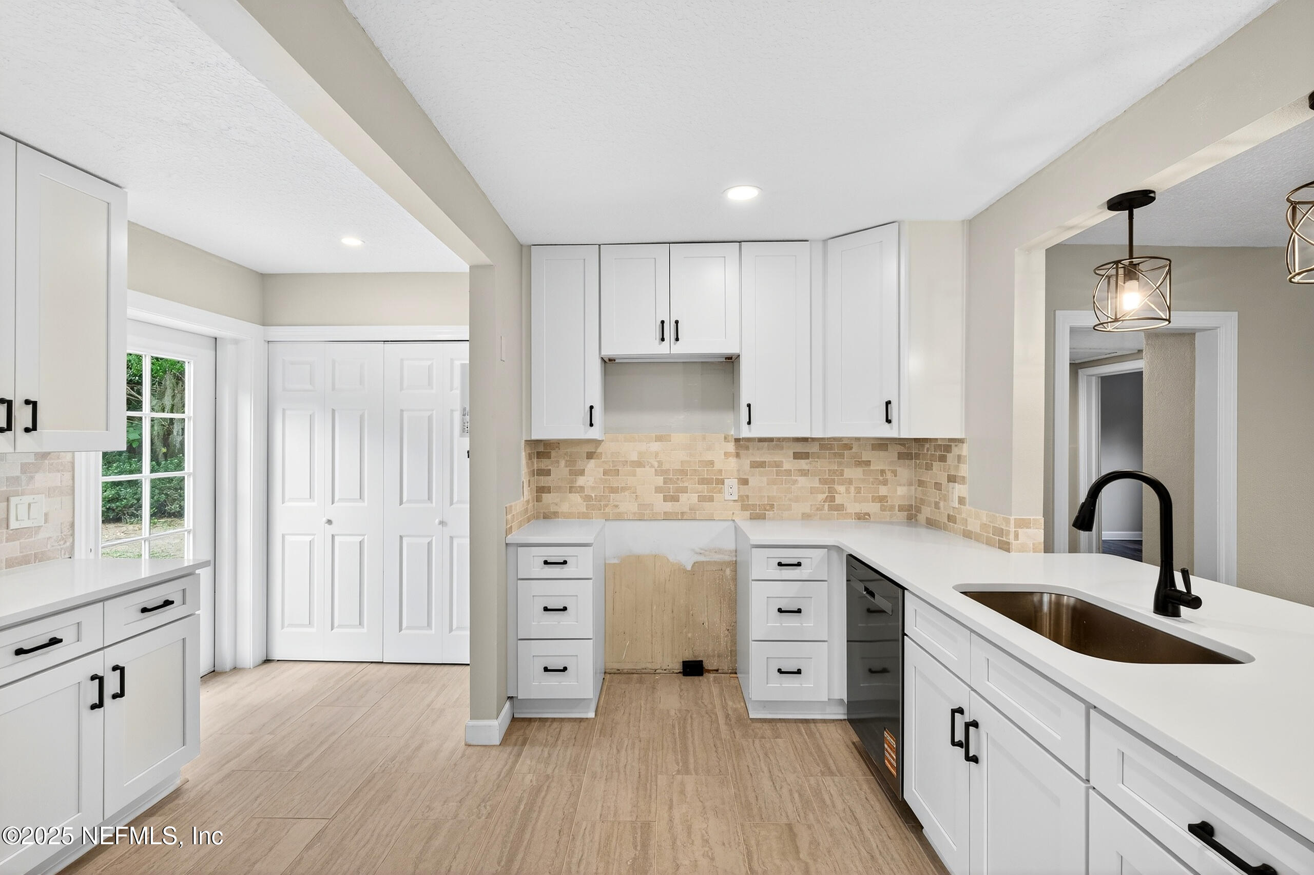 9906 Jeanette Road Jacksonville, FL 32246 - Photo 8 of 32 a kitchen with granite countertop a sink stove and cabinets