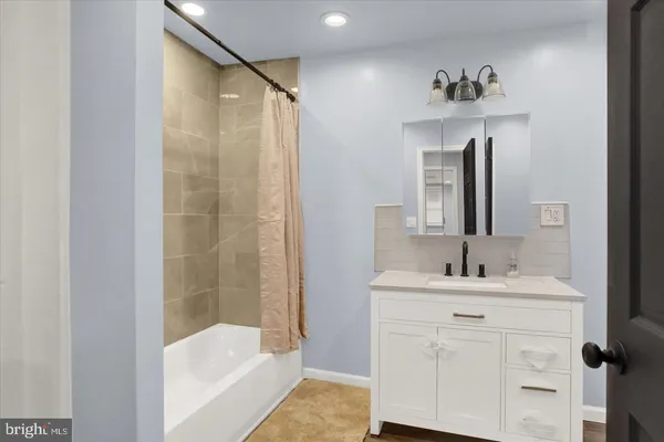a bathroom with a sink vanity tub and shower