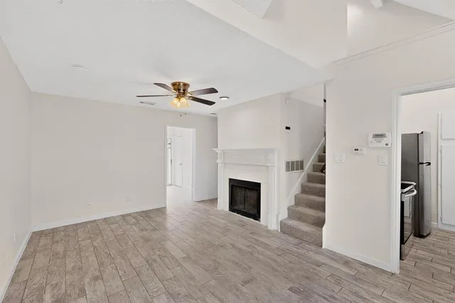 a view of empty room with wooden floor and fireplace