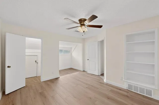 a view of a livingroom with a hardwood floor and a ceiling fan