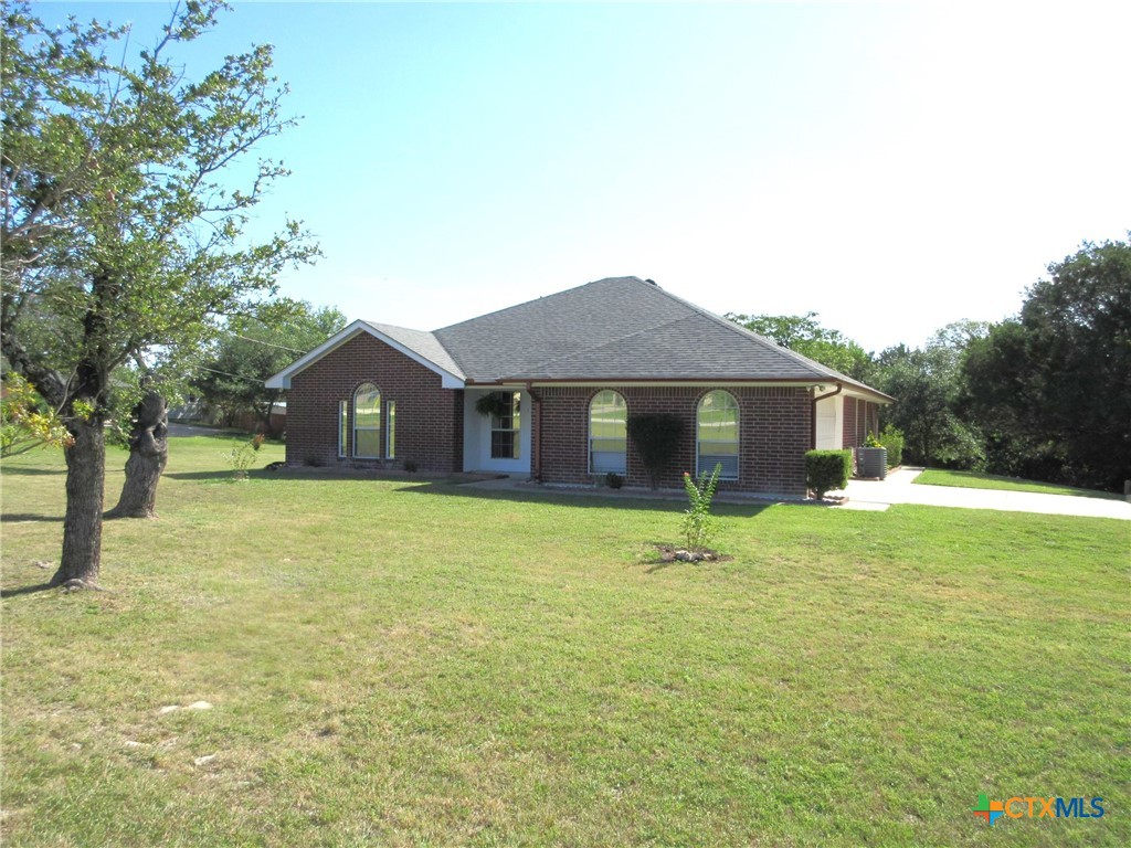 a front view of a house with yard and tree