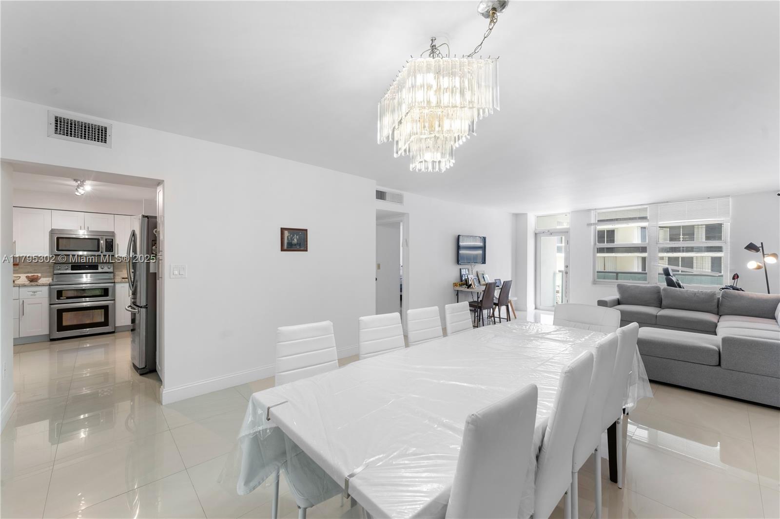 9511 Collins Avenue, Unit 301 Surfside, FL 33154 - Photo 2 of 15 a large bedroom with a bed and a chandelier