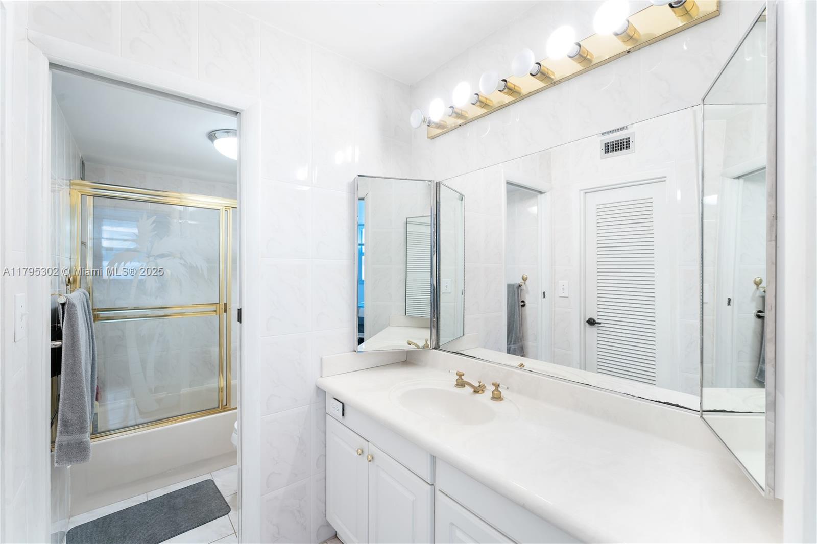 9511 Collins Avenue, Unit 301 Surfside, FL 33154 - Photo 9 of 15 a bathroom with a double vanity sink mirror and double