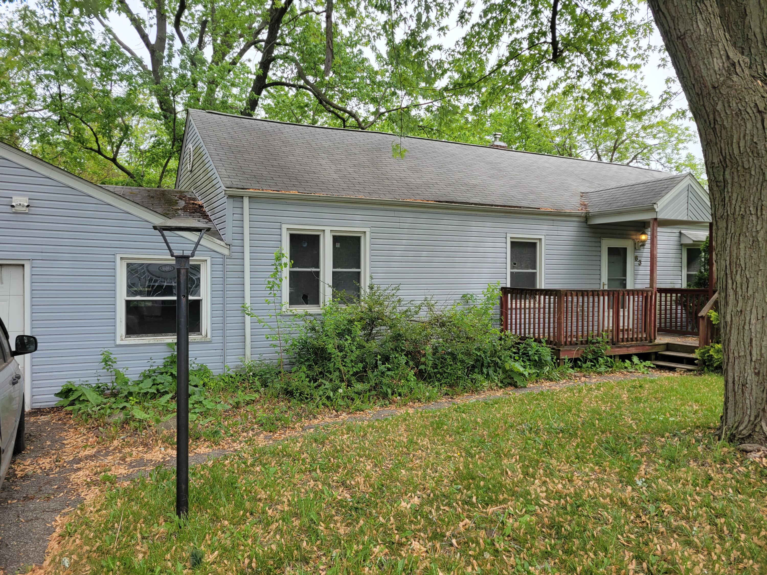 63 Deerpath Road Merrillville, IN 46410 - Photo 2 of 14 a brick house with a yard plants and large tree