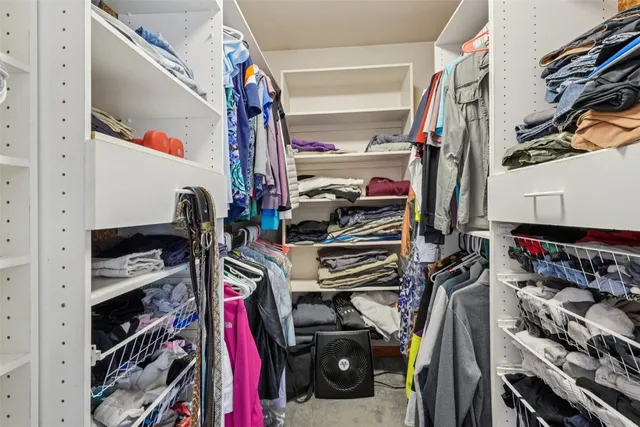 a view of walk in closet with clothes and shoes