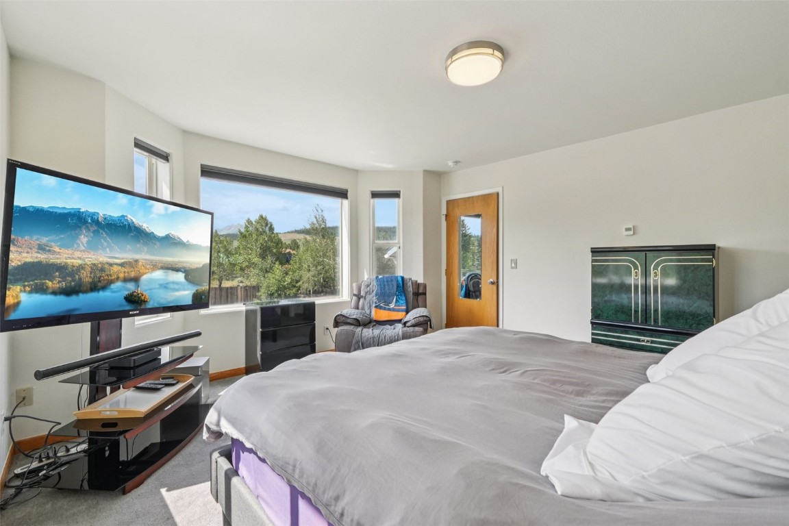 380 Riley Road Silverthorne, CO 80498 - Photo 4 of 49 a large bedroom with a bed and a large window with the outer view