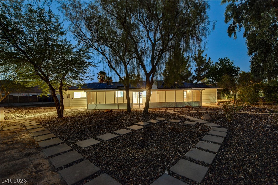 7631 Bermuda Road Las Vegas, NV 89123 - Photo 61 of 64 Illuminated at dusk, this inviting property showcases a charming home with a beautifully landscaped front yard.