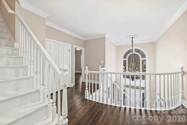 a view of staircase with wooden floor and white walls