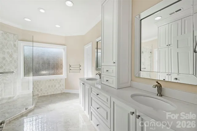 a bathroom with double vanity and a bathtub
