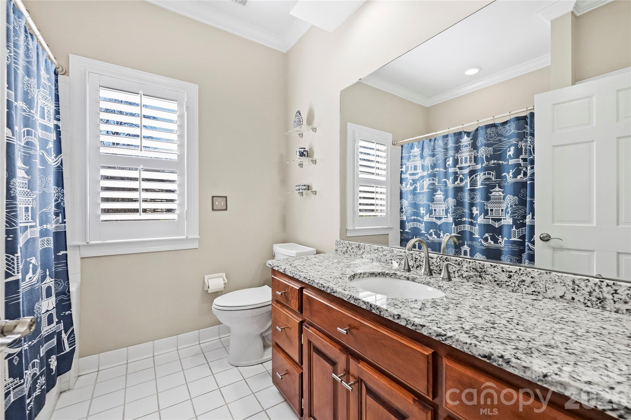 5242 Colony Road Charlotte, NC 28226 - Photo 25 of 34 a bathroom with a granite countertop sink a toilet a mirror and shower