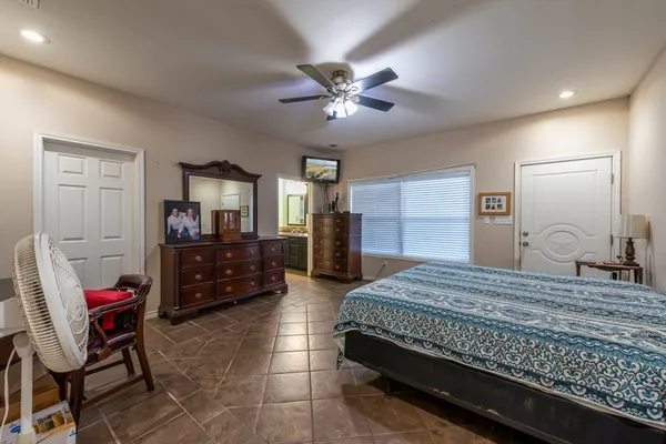 a bedroom with a bed a dresser and chair