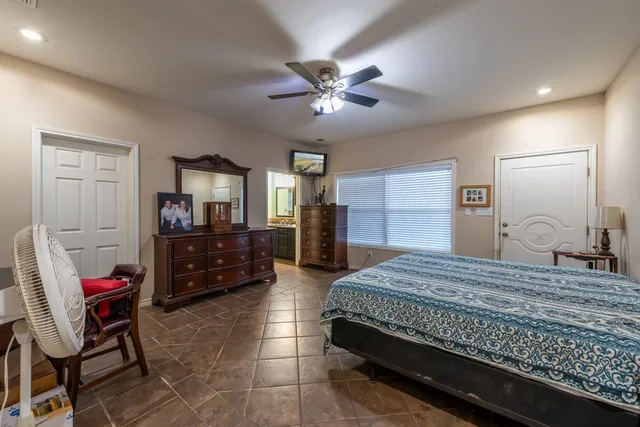 a bedroom with a bed a dresser and chair