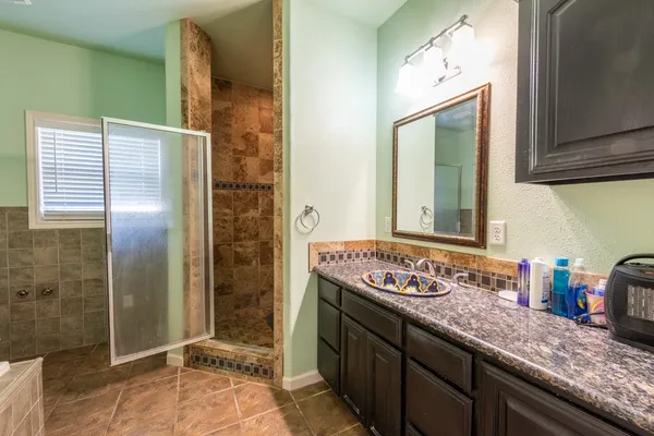 a bathroom with a granite countertop sink and a mirror