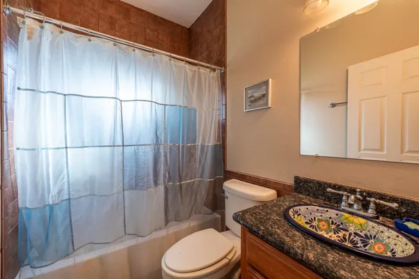 a bathroom with a granite countertop toilet sink and shower